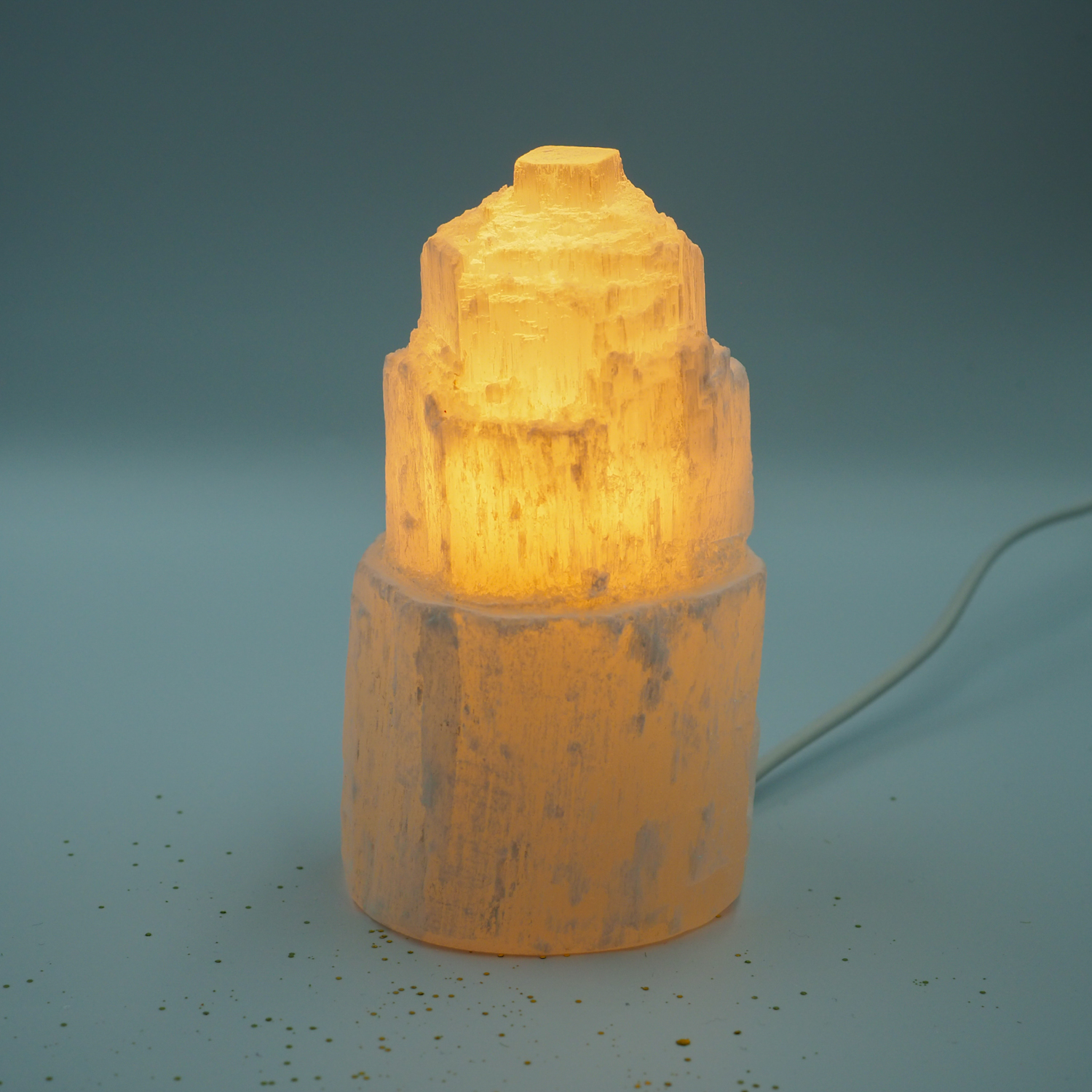 Rozsvietená selenitová lampa na svetlom pozadí
